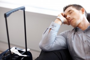 Tired young man sleeping at the airport lounge - Waiting for flight